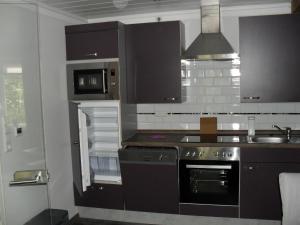 a kitchen with black and white cabinets and a stove at Ferienhof Schlachter in Berumbur