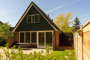 una casa con techo negro y patio en Nieuw: Kom in de Bedstee Uniek!, en Winterswijk