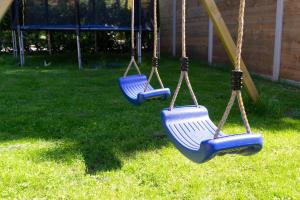 two swings sitting in the grass in a yard at Nieuw: Kom in de Bedstee Uniek! in Winterswijk