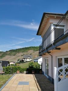 a house with a balcony and a patio at Weingut Amlinger&Sohn in Neef
