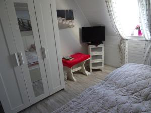 a bedroom with a bed and a tv and a window at Hofwohnung Steinbergkirche in Steinbergkirche