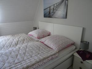 a bedroom with a bed with pink and white sheets and pillows at Hofwohnung Steinbergkirche in Steinbergkirche
