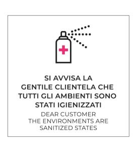een fles ontsmettingsmiddel met een rood kruis erop bij Hotel Ares Milano in Milaan