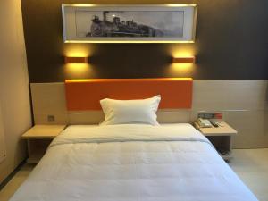 Una cama o camas en una habitación de 7Days Premium Dalian Development Zone Wucaicheng rail station