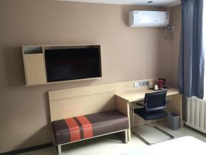 a small room with a desk and a tv on the wall at 7Days Premium Dalian Development Zone Wucaicheng rail station in Dalian