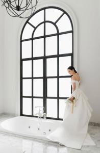 a woman in a wedding dress standing in front of a bath tub at Hotel Once Bangkok in Bangkok