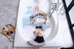 a person laying in a bath tub in a toilet at Hotel Once Bangkok in Bangkok