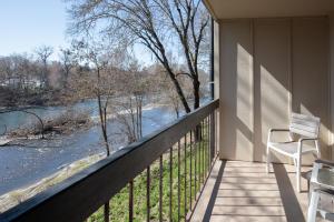a balcony with two chairs and a view of a river at Riverside Inn in Grants Pass
