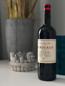 a bottle of red wine sitting on a table at Spuren im Sand in Sankt Peter-Ording