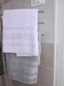B&B Regina Margherita في لاكويلا: منشفةبيضاء معلقة على رف مناشف في الحمام