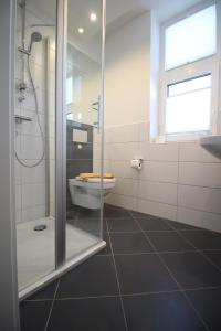 La salle de bains est pourvue de toilettes et d'une douche en verre. dans l'établissement Spuren im Sand, à Sankt Peter-Ording
