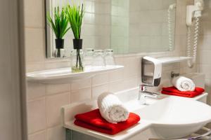 a bathroom with a sink and a toilet and a mirror at Pension Waldfriede in Bad Tatzmannsdorf +51 photos