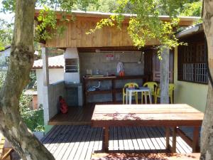 a wooden deck with a table and a kitchen at Magic Island Casas in Florianópolis