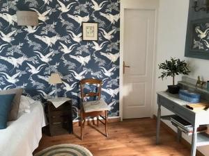 una camera da letto con carta da parati blu e bianca con uccelli di Grand Mainguet a Saint-Lambert-la-Potherie