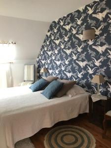1 dormitorio con 1 cama con papel pintado azul y blanco en Grand Mainguet, en Saint-Lambert-la-Potherie