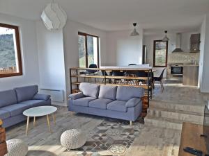 ein Wohnzimmer mit 2 blauen Sofas und einem Tisch in der Unterkunft Farmhopping Village in Dobărsko