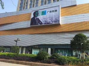 a building with a large sign on the side of it at 7Days Premium Neijiang Wanda Square in Neijiang