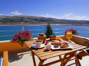 a table with a breakfast of coffee and pastries on a balcony at Boutique Villa Revelin in Pag