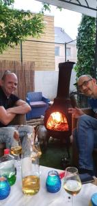 a group of men sitting around a table with a fireplace at Schuttershof Heerlen - Adults Only in Heerlen