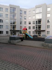 un parque infantil con un tobogán frente a algunos edificios en Palm apartment studio Riga, en Riga