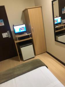 a small room with a door and a television at Hotel Steinhausen in Blumenau
