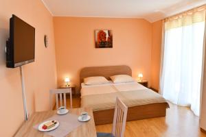 1 dormitorio con 1 cama, TV y mesa en Apartments Villa Miranda en Vodice