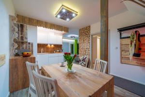 a kitchen and dining room with a wooden table and chairs at Apartamenty u Gąsieniców Zakopane in Zakopane