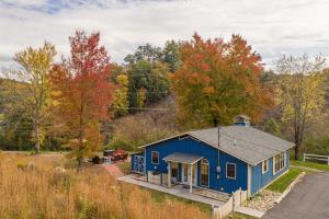 a blue house in the middle of the woods at Across from Dollywood w FREE Dollywood ticket, pets ok wfee, arcade, hot tub in Pigeon Forge