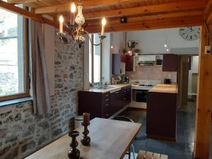 L'Ecole في دينانت: مطبخ مع طاولة وساعة على الحائط