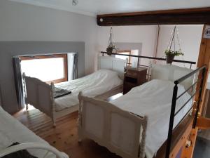 1 dormitorio con 2 camas y ventana en L'Ecole, en Dinant