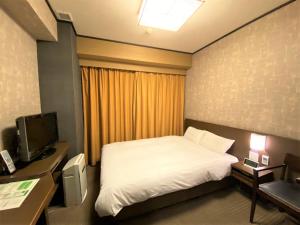 a hotel room with a bed and a television at Dormy Inn Premium Kyoto Ekimae Natural Hot Spring in Kyoto
