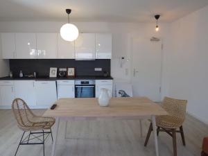uma cozinha com uma mesa de madeira e 2 cadeiras em L8 Street - Q2 16 em Mannheim