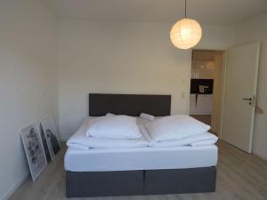 een slaapkamer met een bed met witte lakens en een lamp bij L8 Street - Q2 16 in Mannheim