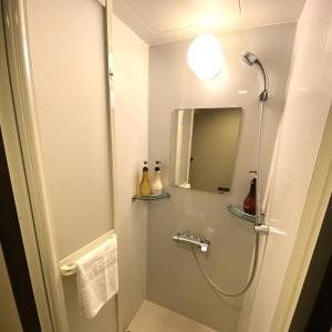 a bathroom with a shower and a mirror at Dormy Inn Premium Kyoto Ekimae Natural Hot Spring in Kyoto