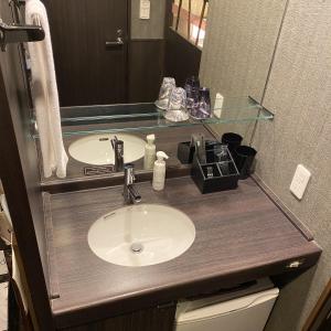 a bathroom counter with a sink and a mirror at Dormy Inn Premium Kyoto Ekimae Natural Hot Spring in Kyoto