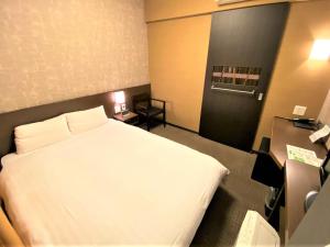 a bedroom with a white bed in a room at Dormy Inn Premium Kyoto Ekimae Natural Hot Spring in Kyoto