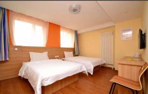 ハルビン市にある7Days Inn Harbin Pioneer Road Xilong Marketのベッドが2つと窓があるホテルの部屋