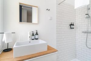 a white bathroom with a sink and a shower at Casa Boma Lisboa - Spacious and Contemporary Apartment - Campo II in Lisbon