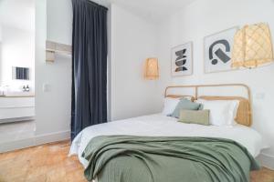 a bedroom with a bed with a green blanket on it at Casa Boma Lisboa - Spacious and Contemporary Apartment - Campo II in Lisbon