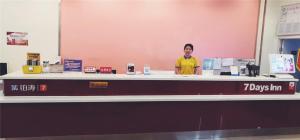 a man standing behind a counter in a store at 7Days Inn Tangshan Silicon Valley Digital City in Tangshan