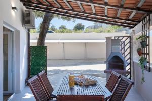 a table and chairs on a patio with a fireplace at Sandy Bay Apartments - free mountainbike rental - in Pješčana Uvala