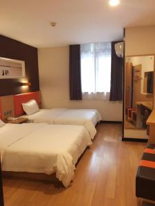 a hotel room with two beds and a window at 7Days Premium Nanjing Xinjiekou Zhangfu Garden Metro Station in Nanjing