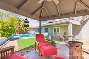 a patio with a red chair and a pool at Relax in style!! Pool, Vegas games, RV parking in Las Vegas