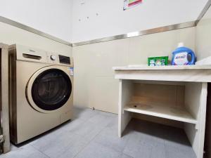 eine Waschküche mit einer Waschmaschine und einer Theke in der Unterkunft 7Days Inn Shangrao Wannian Pharmaceutical Company Store in Wannian