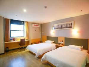 Tempat tidur dalam kamar di 7Days Premium Zhangjiajie Railway Station Square