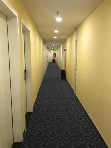 un largo pasillo con un largo pasillo de habitaciones en 7Days Inn Shenzhen Diwang Building Honggui Road Branch, en Shenzhen