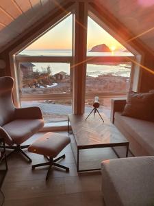 a living room with a couch and a table and a window at Explorers Cabin Lofoten in Offersøya