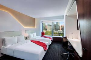2 camas en una habitación de hotel con ventana en The Washington by LuxUrban, en Nueva York
