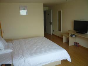 Schlafzimmer mit einem Bett und einem Flachbild-TV in der Unterkunft 7Days Inn Suzhou Wangting Pearl Plaza in Suzhou