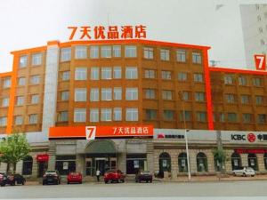 Zhuangheにある7 Days Premium Dalian Zhuanghe Huanghai Avenueの車が目の前に停まった大きな建物
